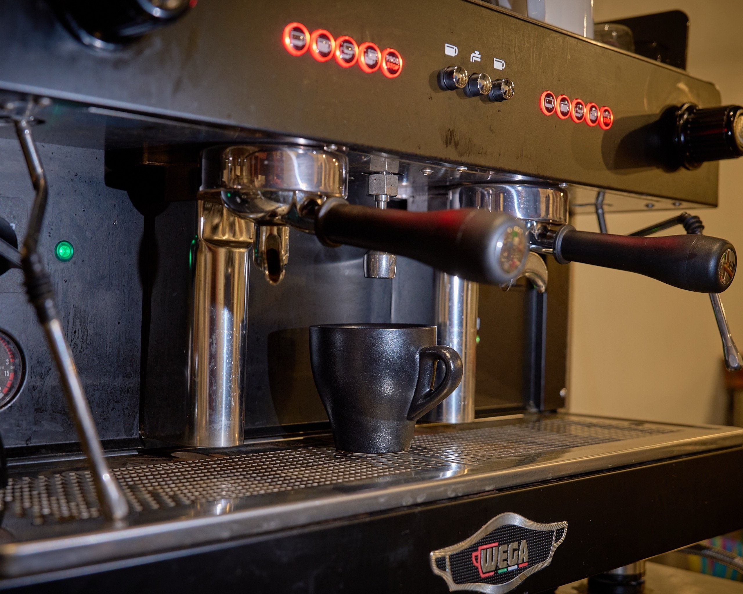 Espresso machine dispensing coffee into a black cup
