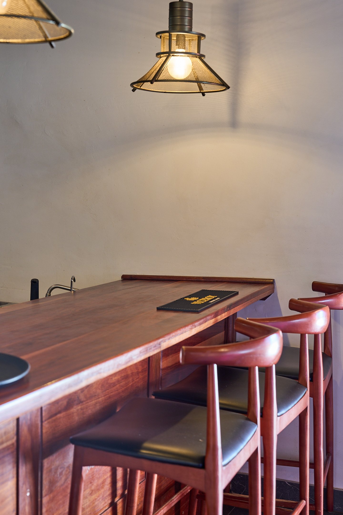 Booth seating in dining room with floral wallpaper and pendant light