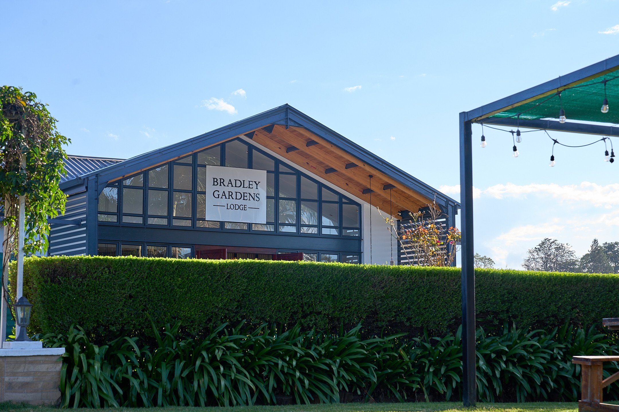 Lodge signage gable above a trimmed hedge