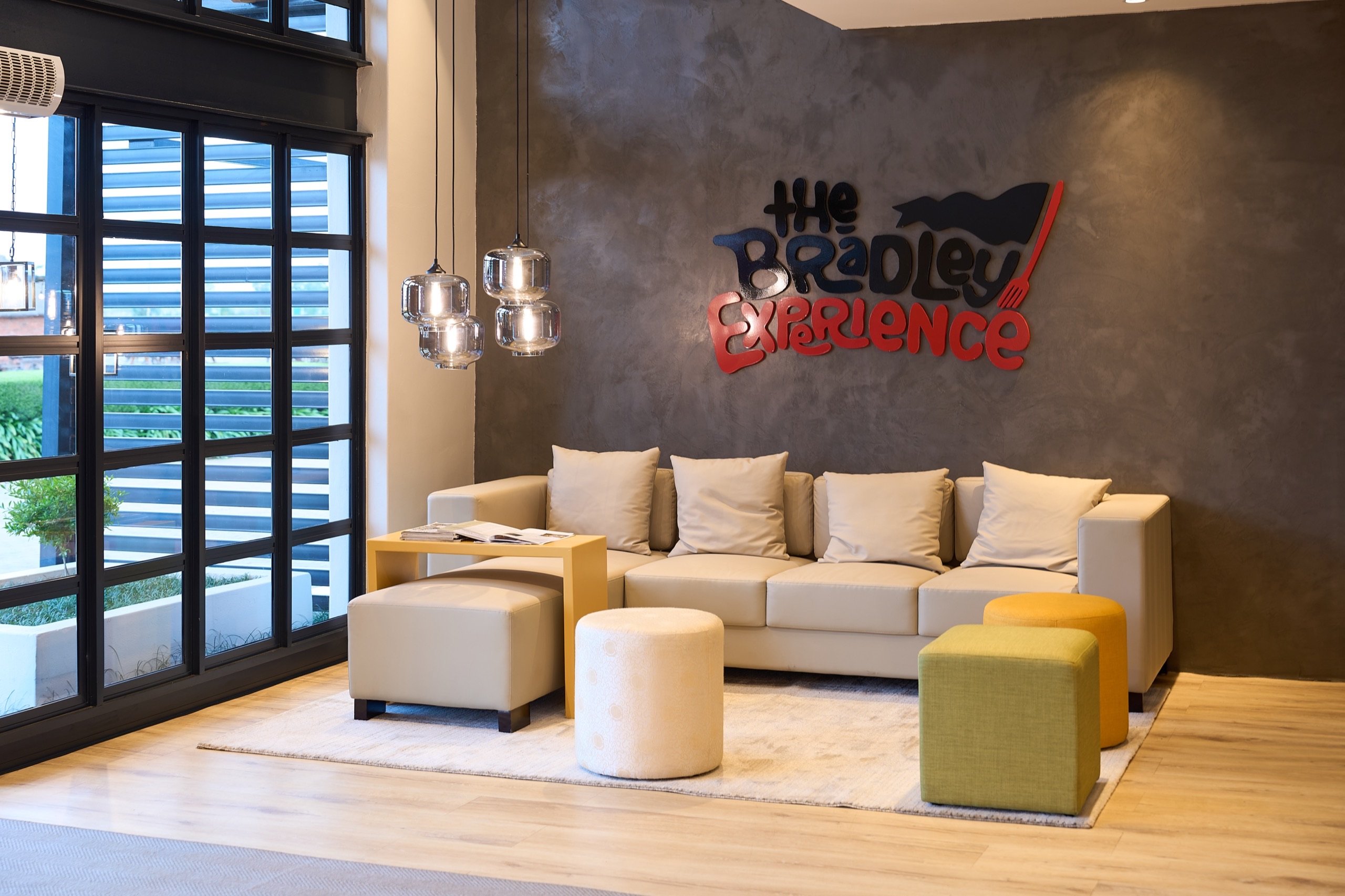 Lounge seating beneath The Bradley Experience wall sign